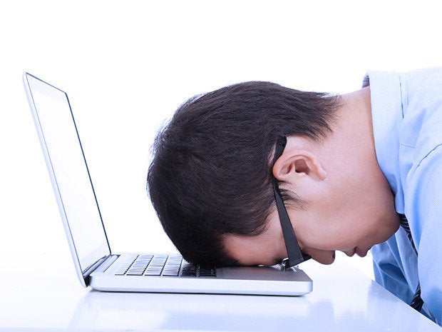 Man with his head resting on his laptop