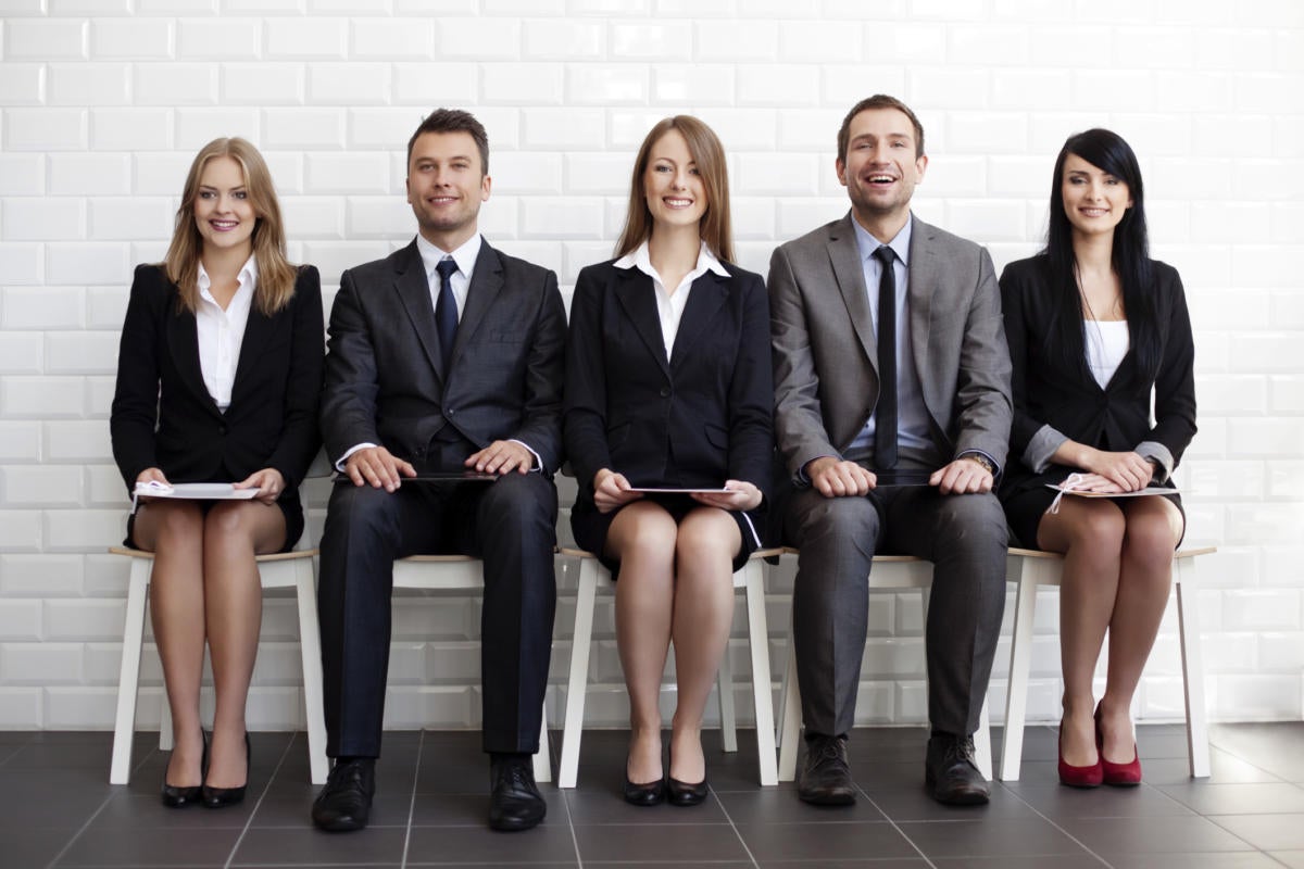 Row of diverse young executives seated on chairs waiting for job interview
