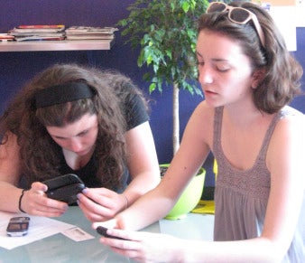 2 girls checking out cell phones