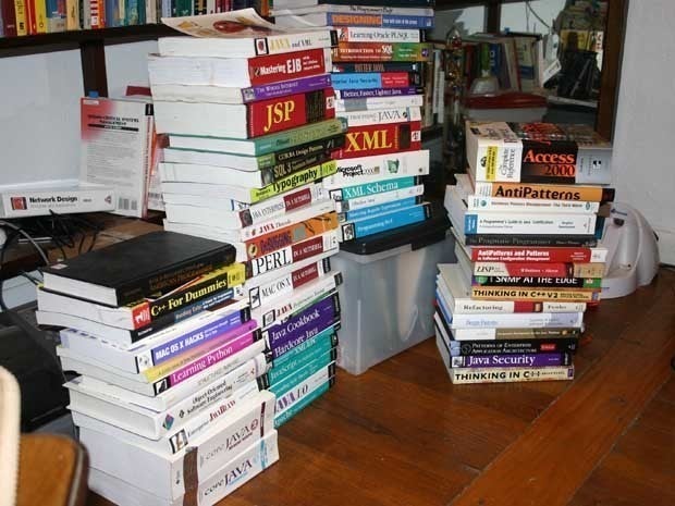 Picture of programming language books piled on the floor