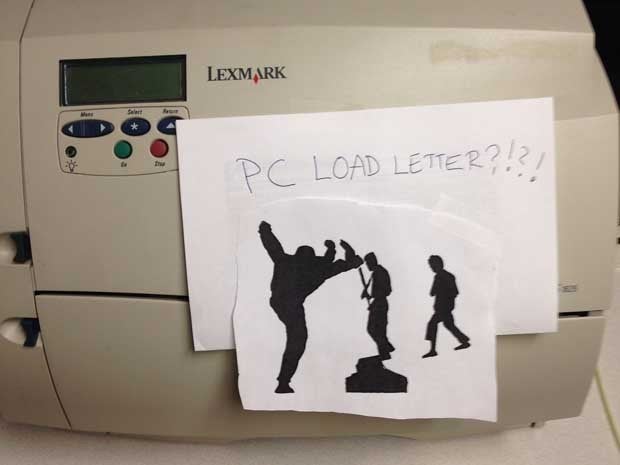 Picture of a printer with a piece of paper taped to it which reads 'PC LOAD LETTER?!'
