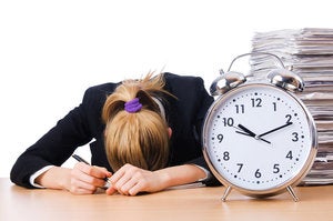 tired woman desk deadline paper work clock alarm