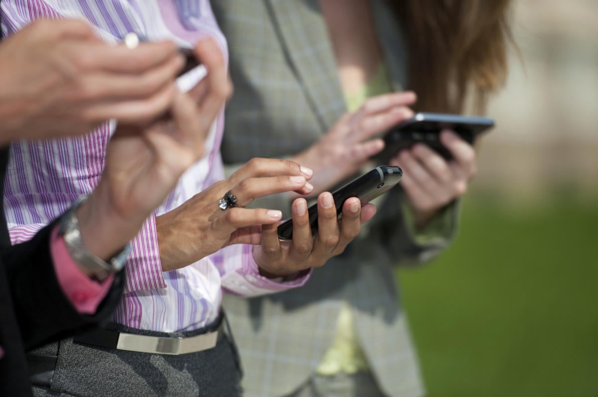 Three business users with mobile devices smartphones
