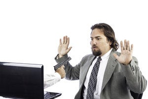 ransomware man pointing gun out of computer security