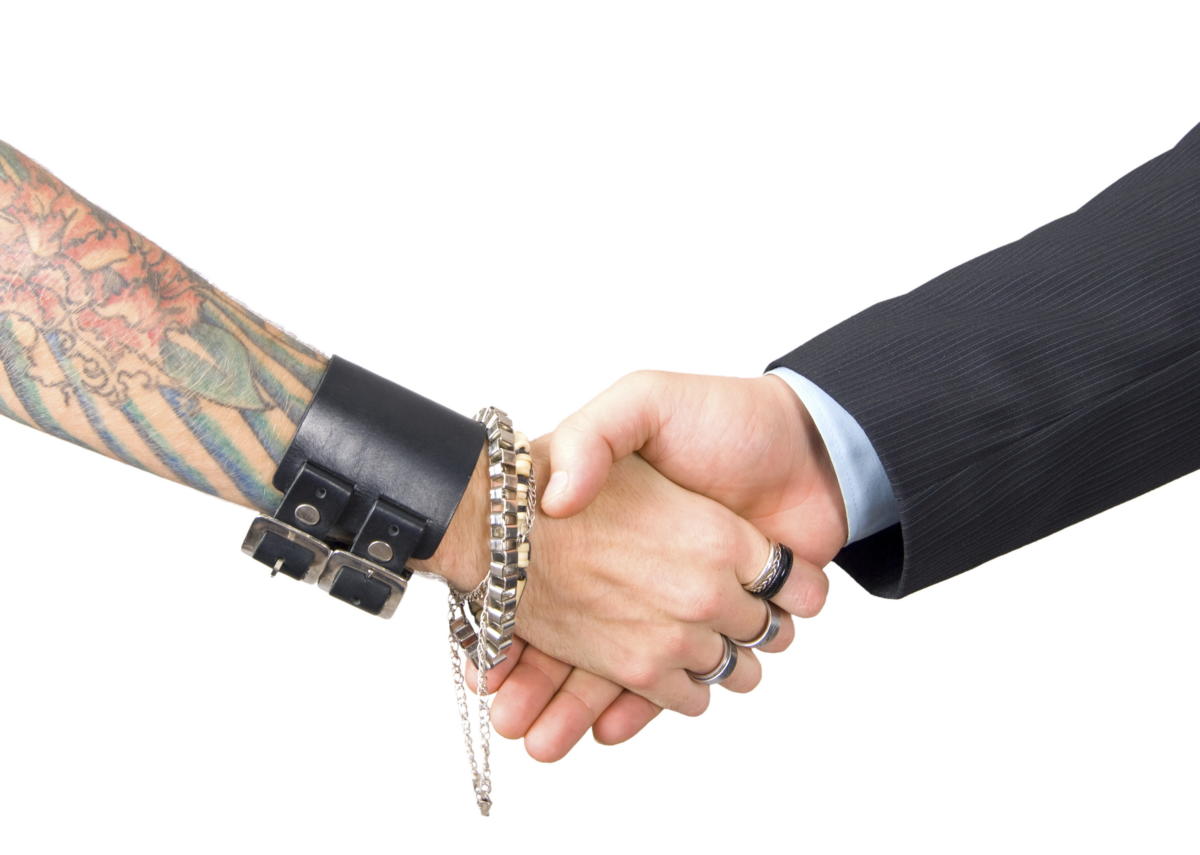 businessman shaking hands with tattooed woman 95363320