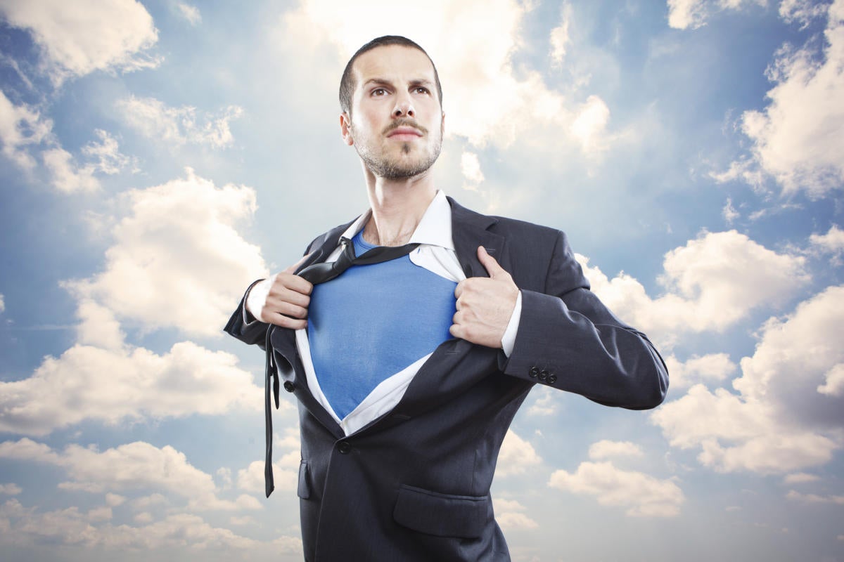 Man busting out of suit into superman among clouds