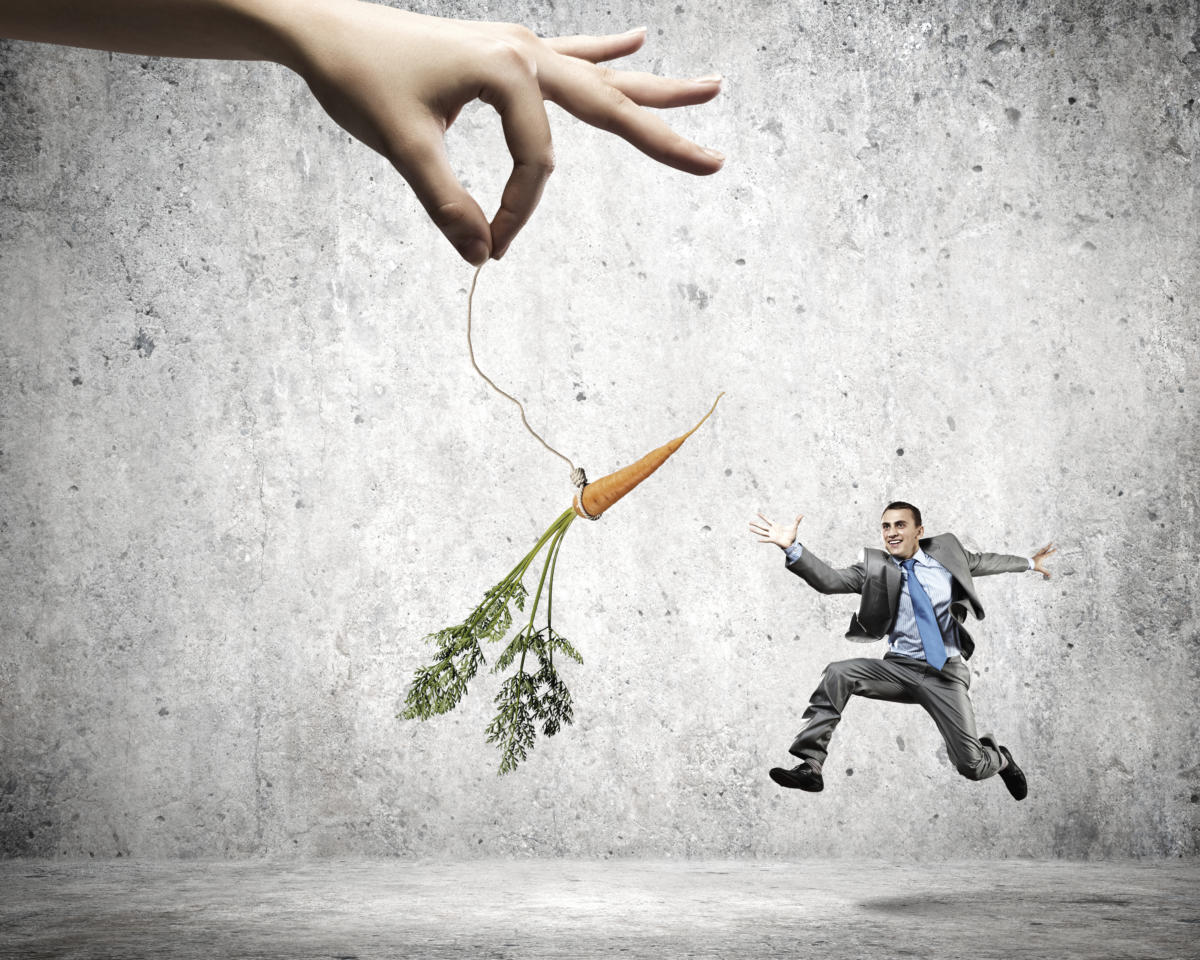 Businessman chasing a dangling carrot.