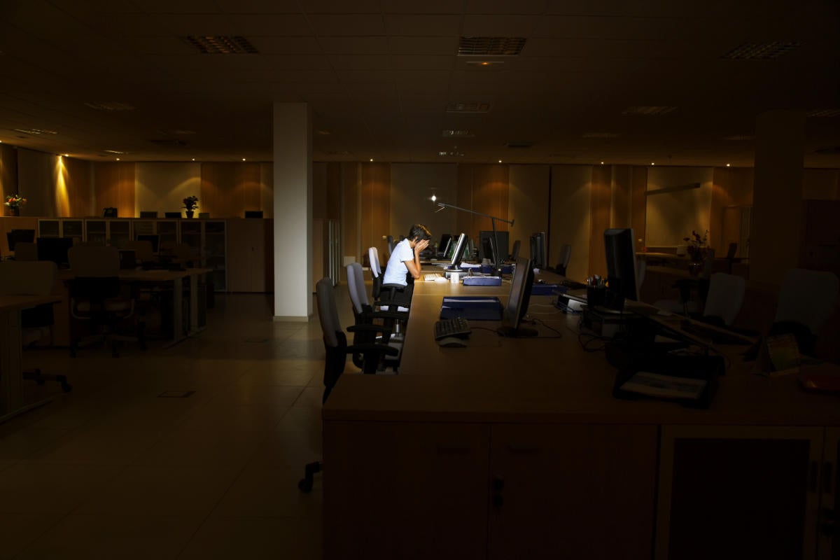 Woman working late at night in a dark office.