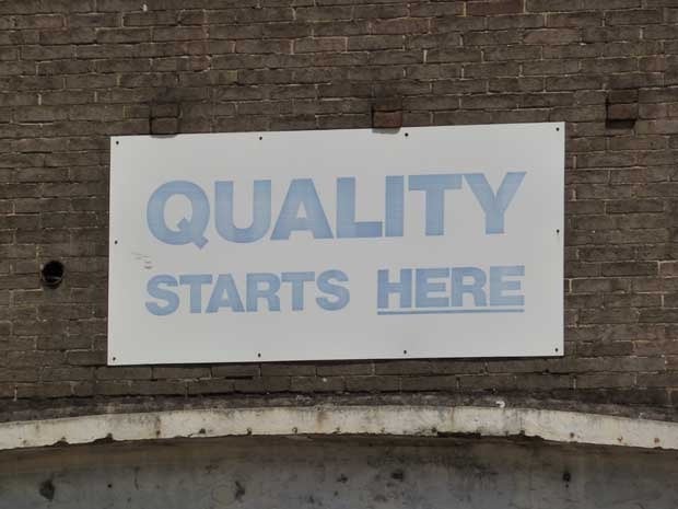 Sign on a wall that says Quality Starts Here