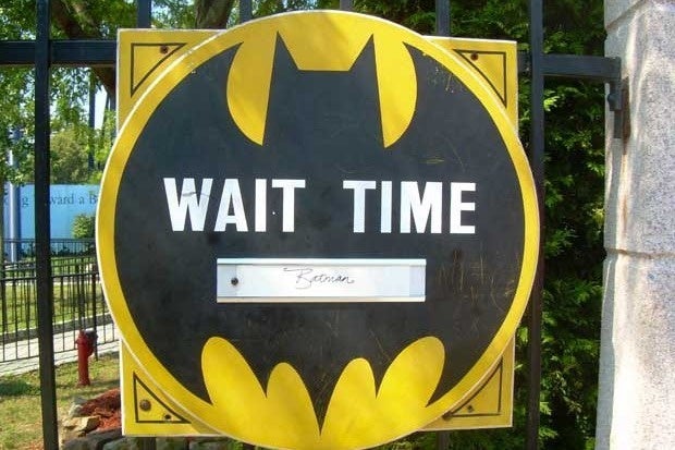 A sign that looks like the Batman logo that says Wait Time
