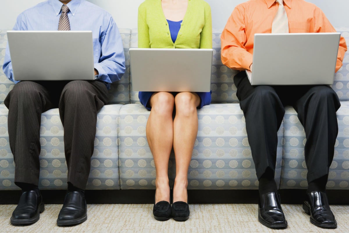 row of three men and women seated on couch with laptops waiting for interview