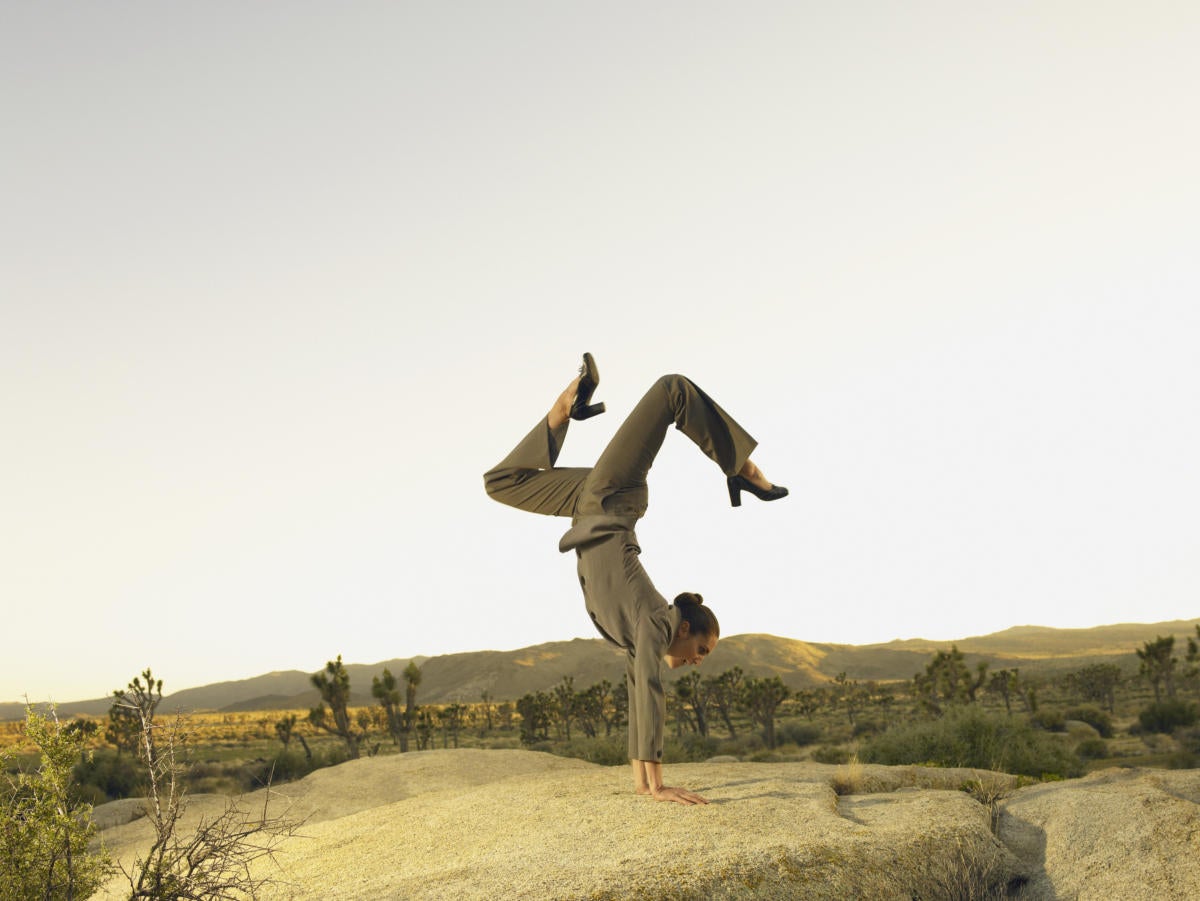 Woman in desert doing handstand showing agility