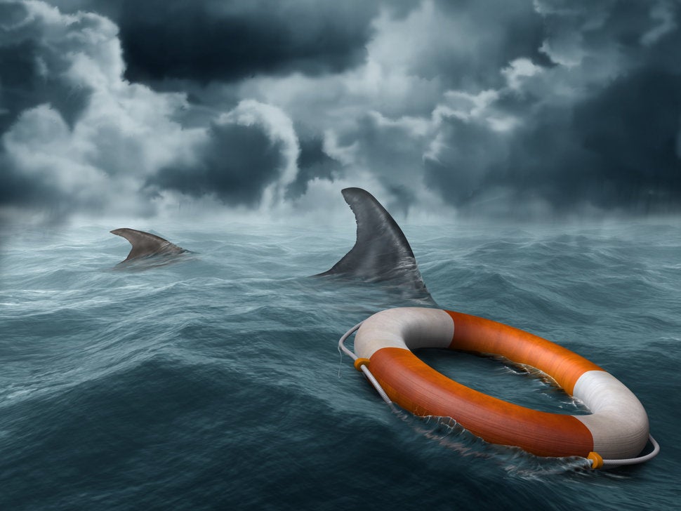 threatening dangerous rough ocean concept with sharks and life preserver
