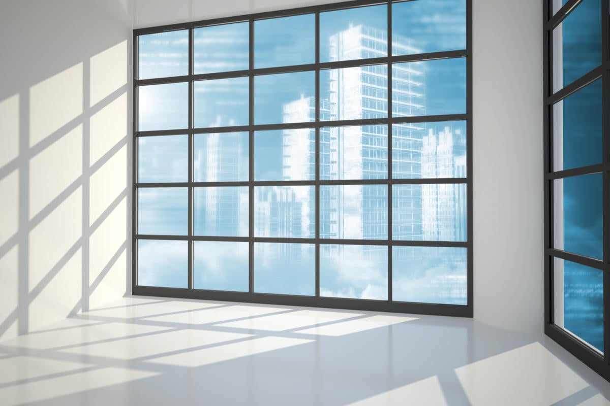 Wall of windows in an office with clouds in the background