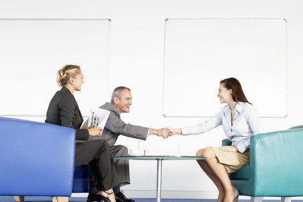 man and women executives sitting in office shaking hands and interviewing
