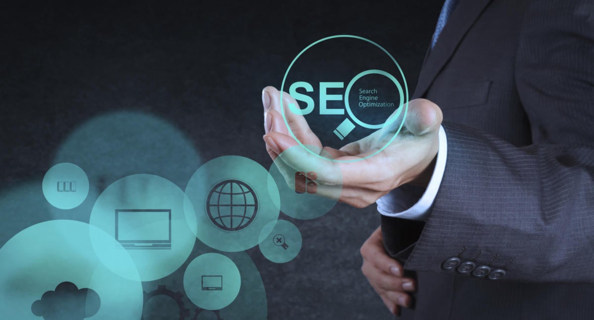Torso of man holding SEO magnifying glass for search