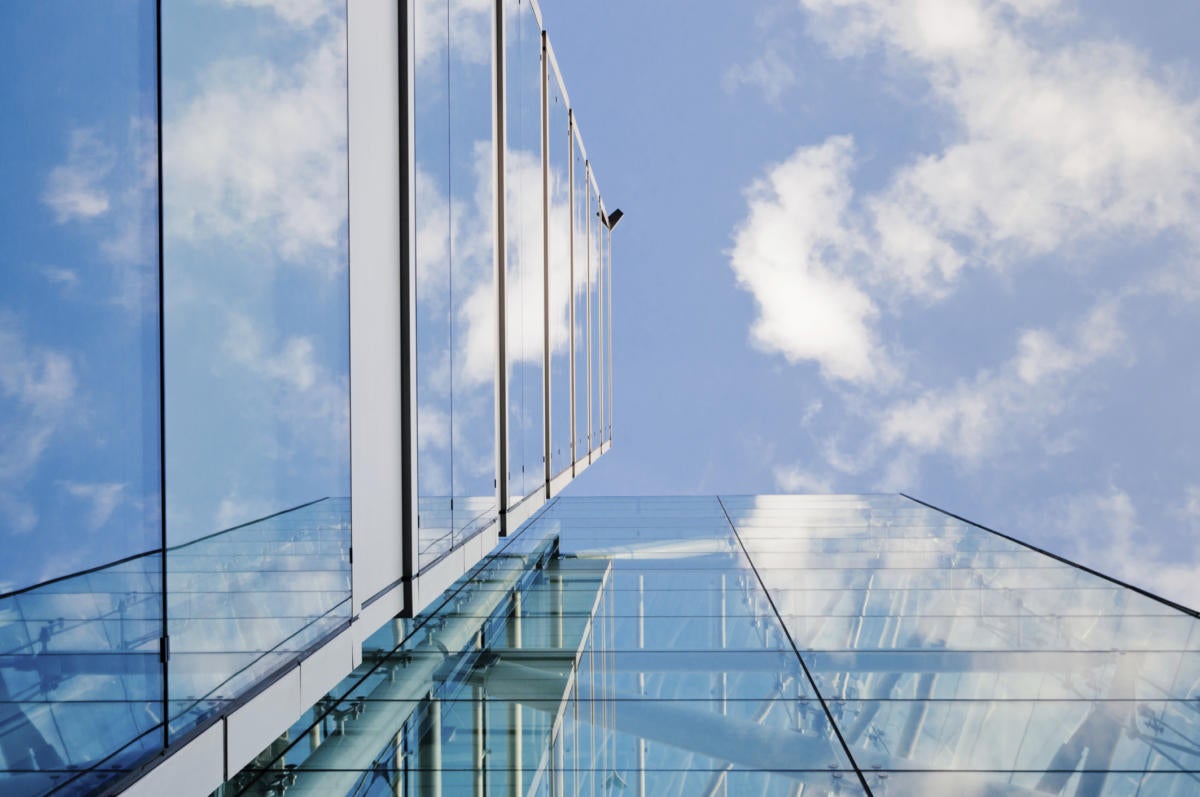 glass building with clouds above