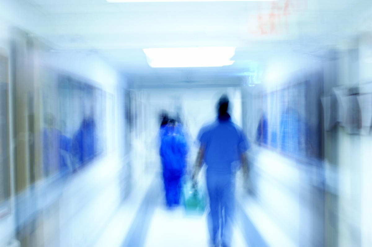 Hospital scene with medical staff in blue scrubs blurred