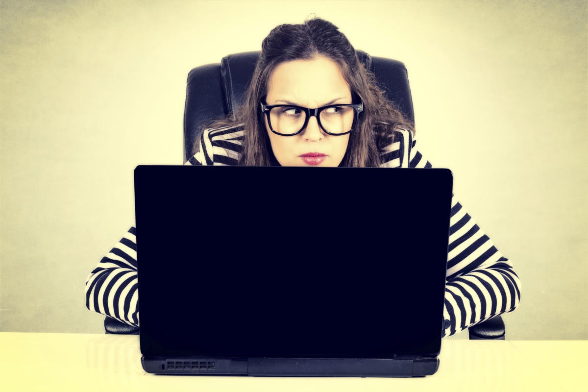 A paranoid user with a laptop computer looks around suspiciously. [credit: Thinkstock]