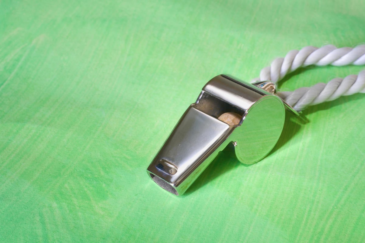 metal whistle on green background