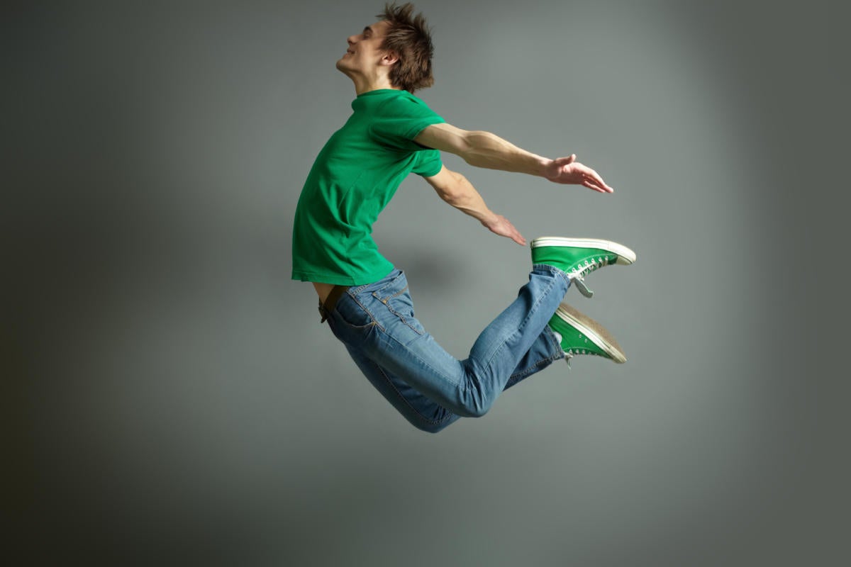 Man in green shirt jumping up in the air