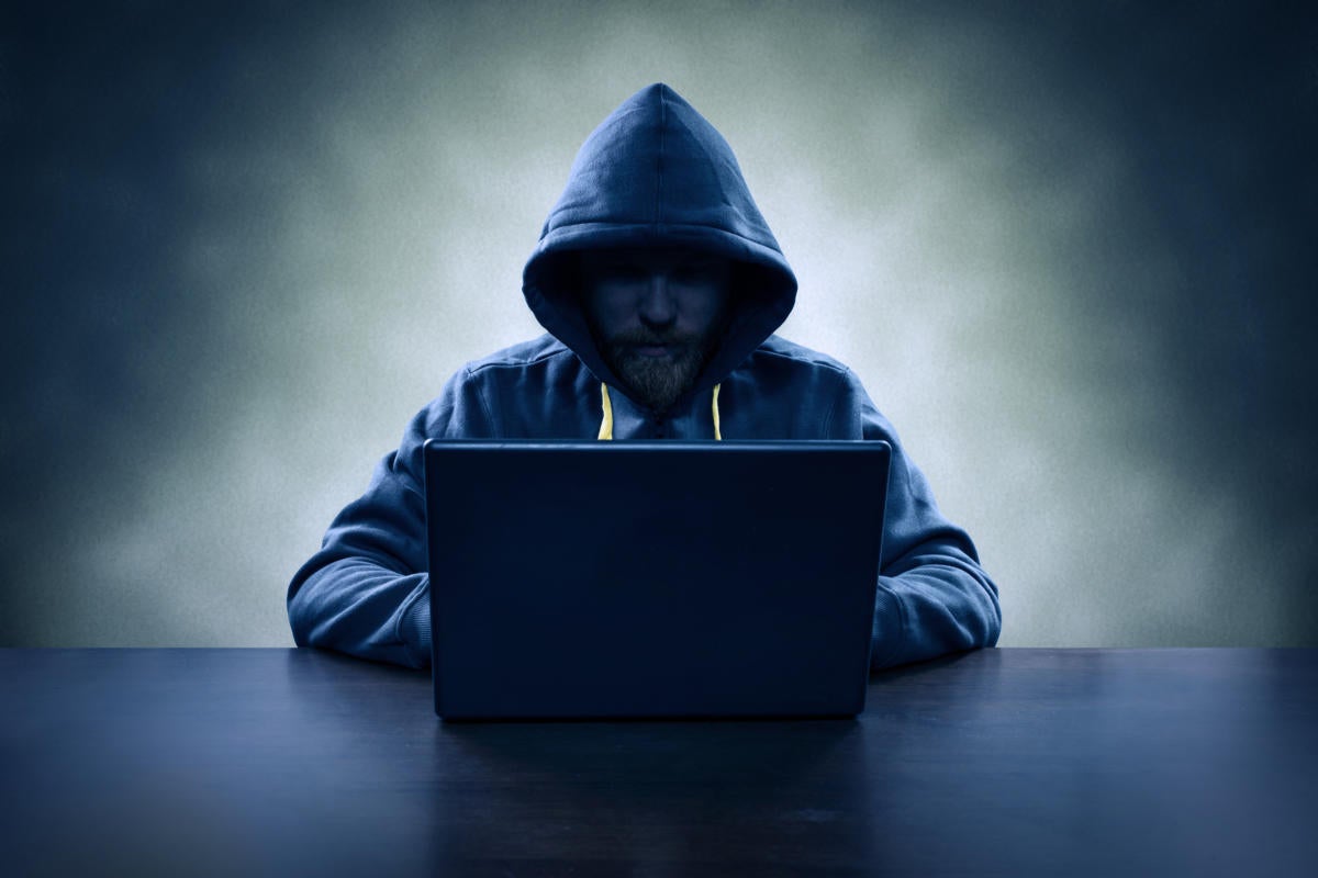 Hacker in silouhette at laptop