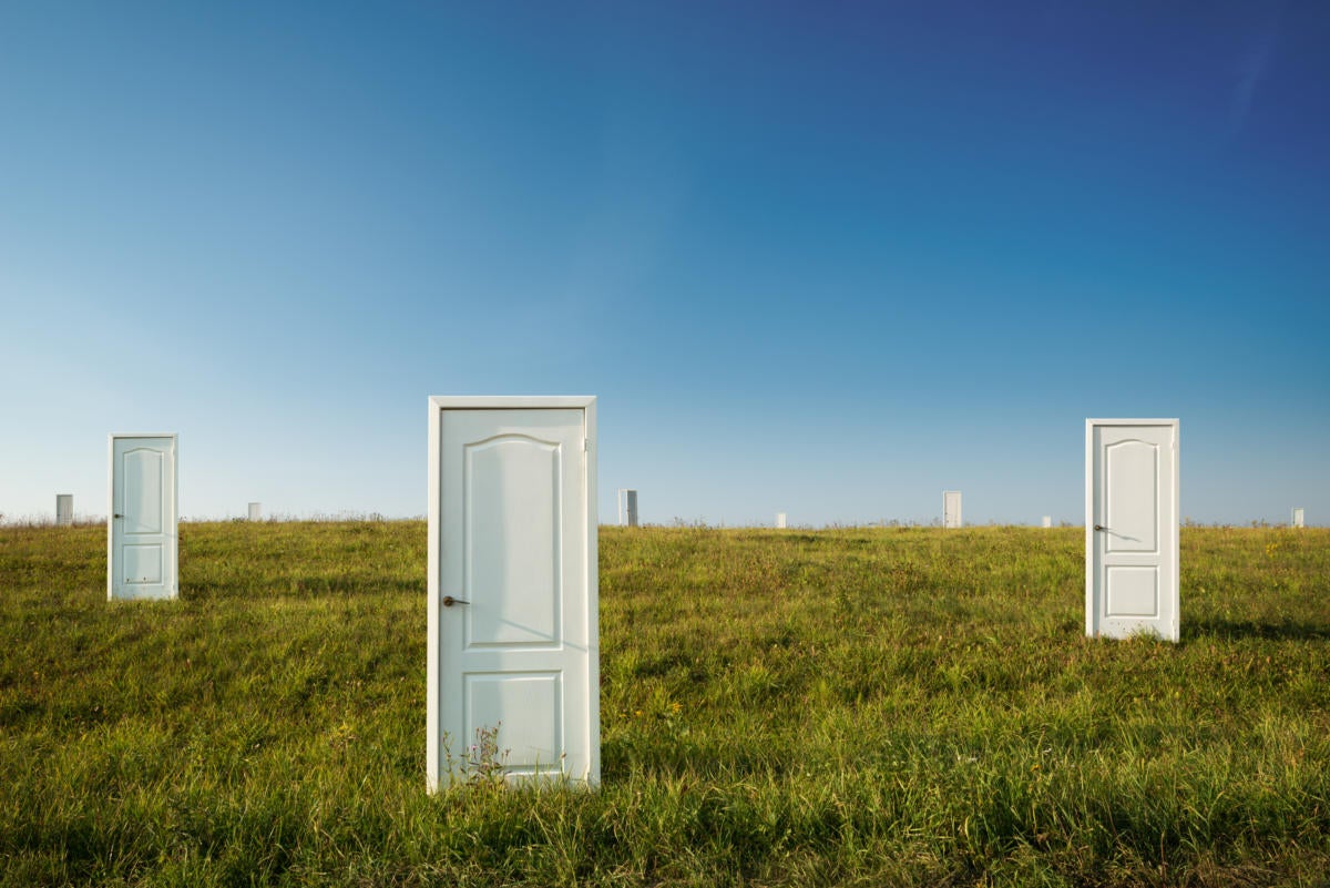 three lone doors in open grassy field