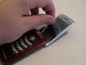 Peeling the plastic cover off one of the BlackBerry Pearl 8220's LCD screens